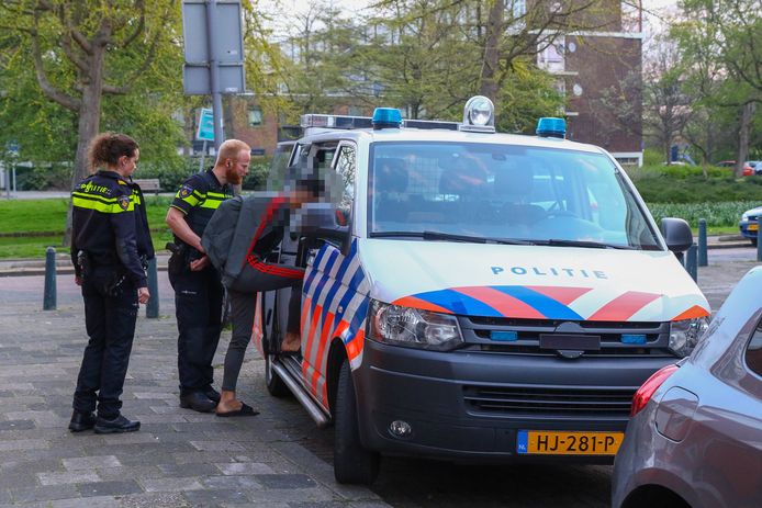 De politie arresteert een van de jonge verdachten.