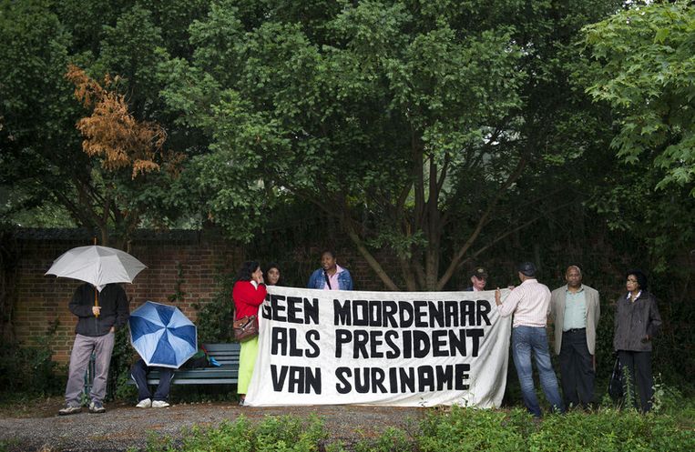 Demonstranten schuilen donderdag voor de regen in Den Haag. Foto ANP Beeld 