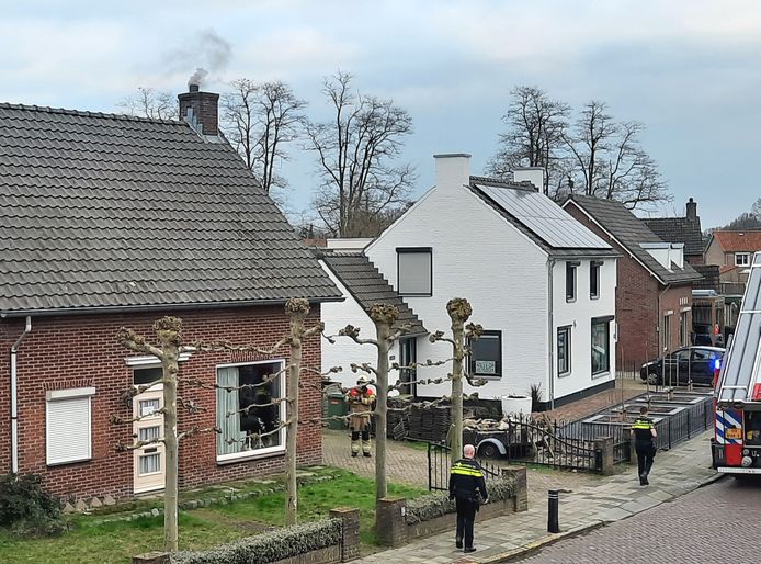 Dikke zwarte rook stijgt op uit de schoorsteen als de brandweer arriveert.