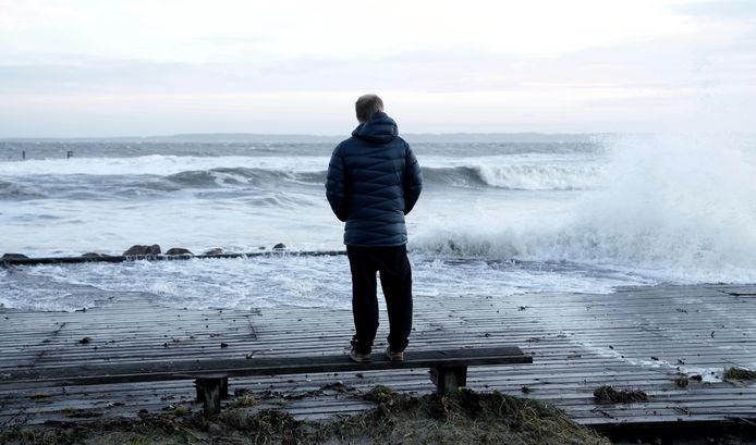 Un homme regarde le rivage après que la tempête Malik a fait monter le niveau des eaux au port de Hornbaek, en Zélande du Nord, au Danemark, le 30 janvier 2022.