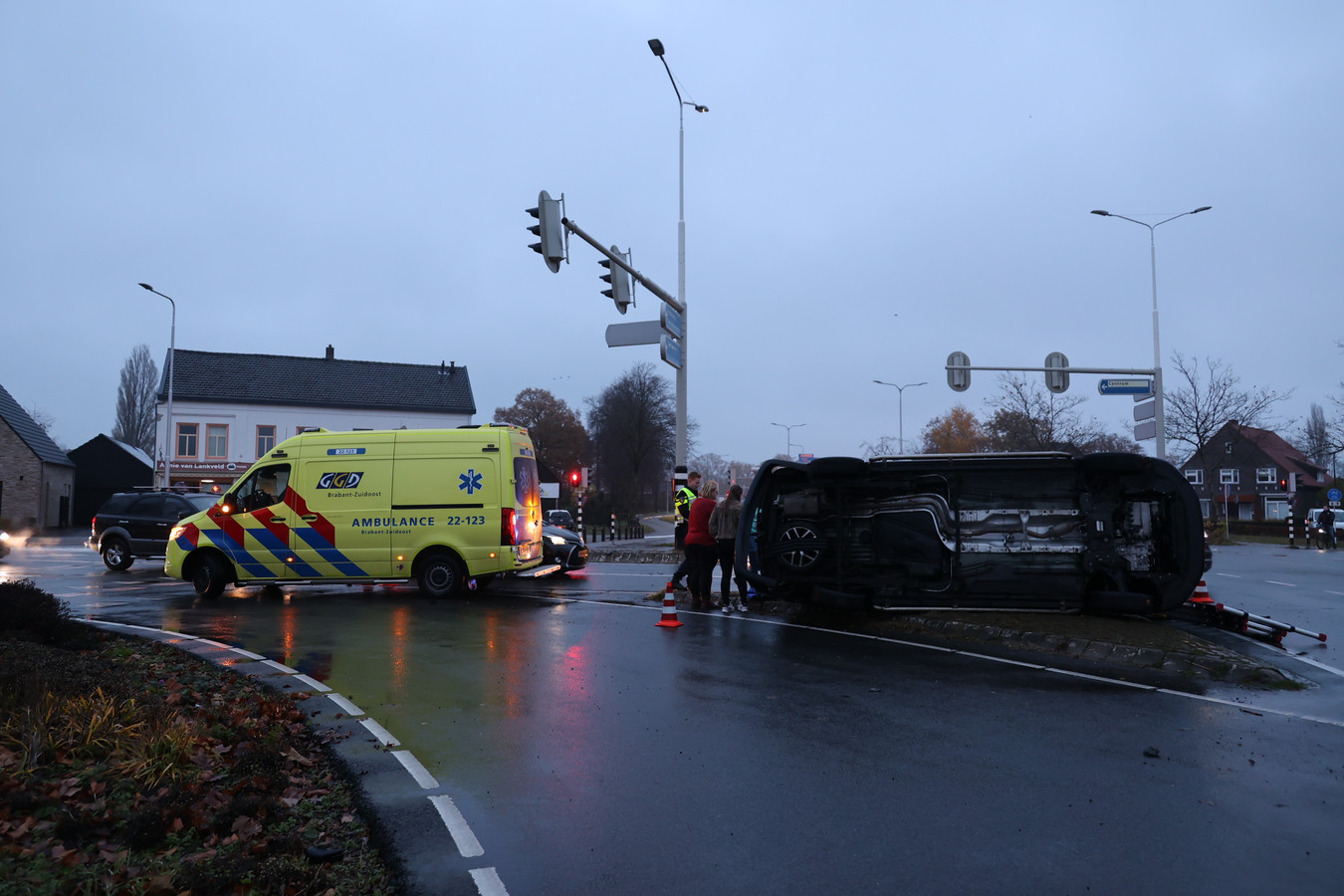 Bedrijfsbus belandt op zijkant op de weg bij botsing met auto in Beek