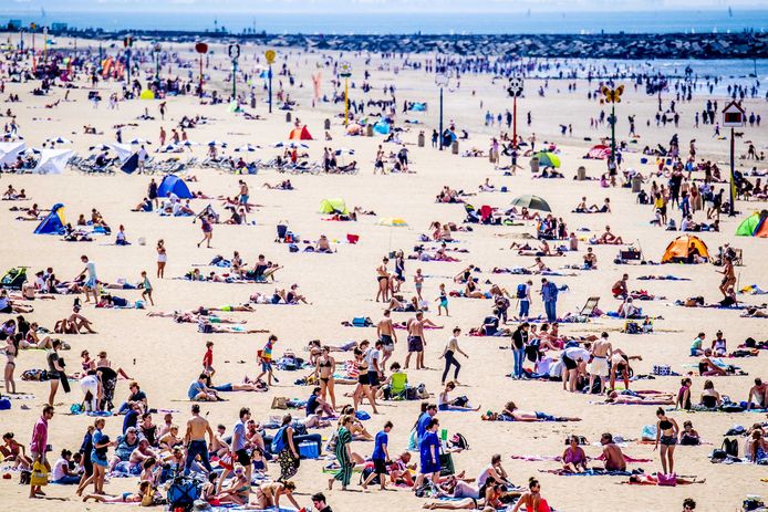 Mensen genieten op het strand van Scheveningen op een zomerse Tweede Pinksterdag