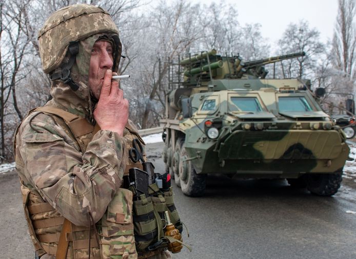 Een Oekraïense soldaat rookt een sigaret bij een gepantserd voertuig buiten Charkiv. (26/02/2022)
