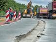 Medewerkers van aannemersbedrijf P. Loeffen verwijderen de vermaledijde betonnen rand van het viaduct over de A50 bij Schaijk.
