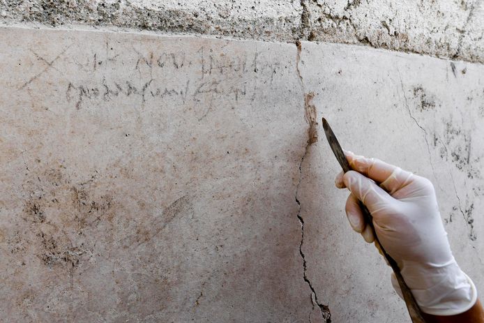 Een archeologe onderzoekt de inscriptie.