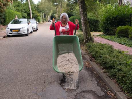 De gemeente doet het niet, dus vult Loes (76) uit Baarn de gaten in het wegdek zelf: ‘Het is levensgevaarlijk’