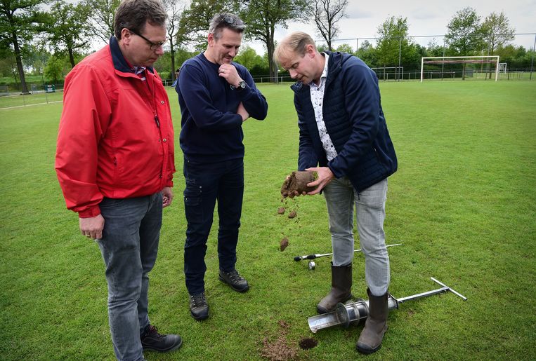 Bij ASV’33 in Aarle-Rixtel krijgen twee medewerkers uitleg over het chemievrij beheren van de voetbalvelden. Beeld Marcel van den Bergh