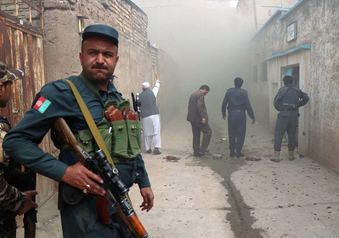 Een Afghaanse politieagent houdt de wacht aan de moskee na de aanslag.