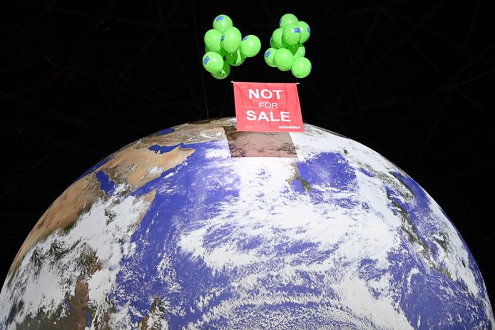 Activisten van milieuclub Greenpeace lieten gisterenavond een enorme ballon op in het congrescentrum in Glasgow, met daarbij het spandoek 'Niet te koop'.