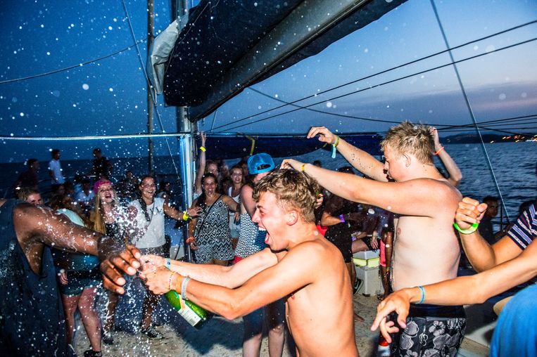 Feestende Nederlandse jongeren tijdens een Sunset Party Cruise voor de kust bij de Spaanse badplaats Blanes.  Beeld ANP