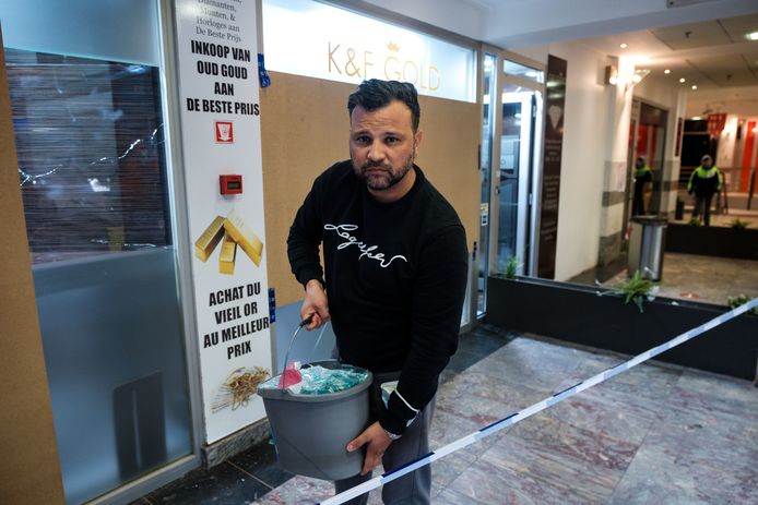 Khalib El Hattab ruimt puin nadat een inbreker het gewapende glas van zijn vitrines aan diggelen sloeg.