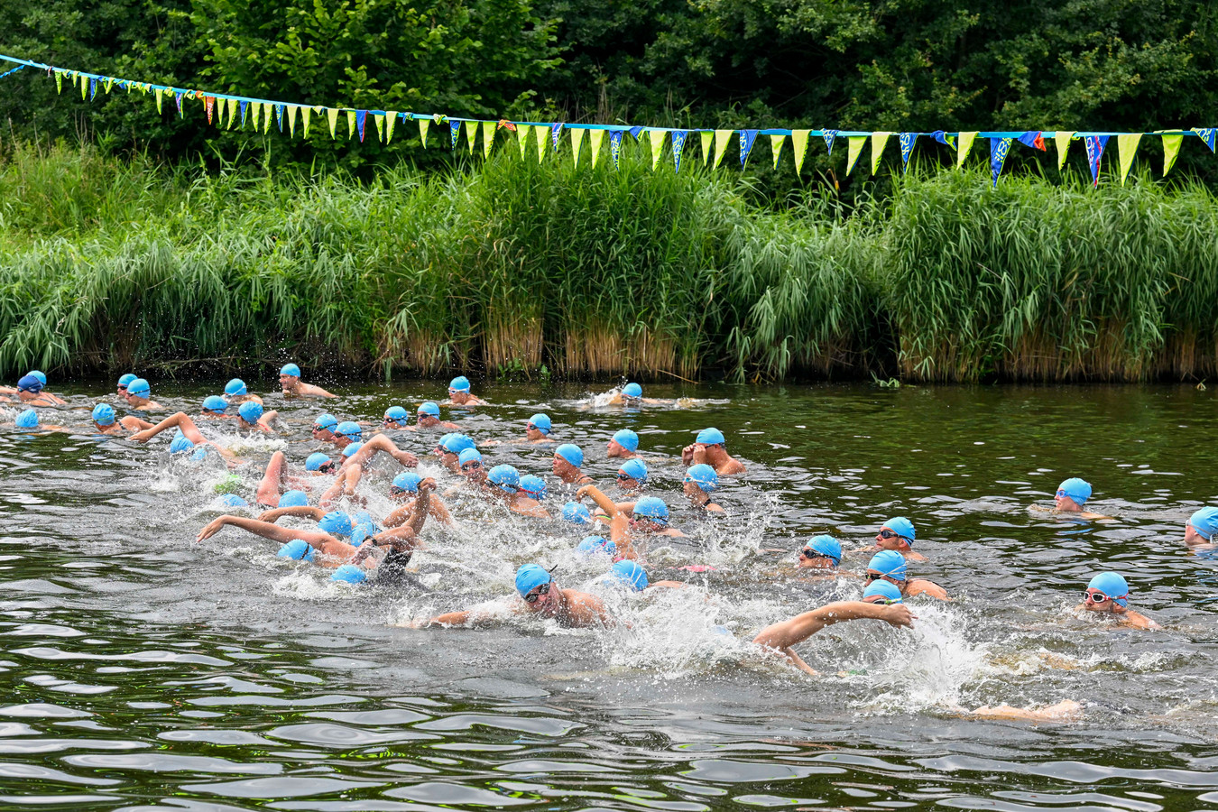 Sportievelingen zwemmen, lopen en fietsen tijdens de Triatlon in Oud