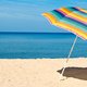 Vliegende strandparasol spiest enkel van vrouw