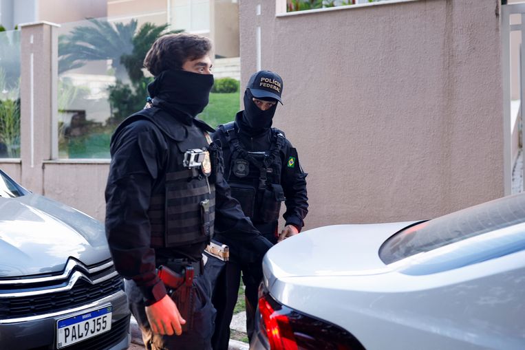 Agenten houden de wacht bij het huis van de minister van Justitie onder Bolsonaro, Anderson Torres, tegen wie een arrestatiebevel is uitgevaardigd vanwege de rellen in Brasilia van afgelopen zondag. Beeld Reuters
