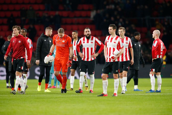PSV'ers lopen met gebogen hoofd van het veld na een teleurstellend gelijkspel tegen FC Twente.