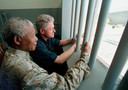 Nelson Mandela en de Amerikaanse oud-president Bill Clinton kijken vanuit de cel op Robbeneiland naar buiten