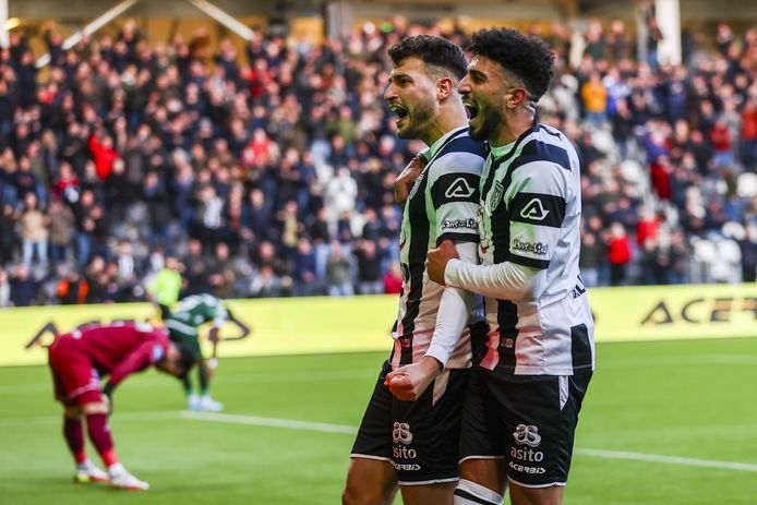 Spelers van Heracles Almelo (r) juichen na de 2-0. Spelers van PEC Zwolle buigen op de achtergrond het hoofd.