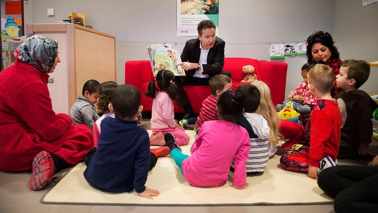 Minister Dijsselbloem in een peuterspeelzaal op de Nationale Voorleesdag in februari. Het kabinet wil de opvang privatiseren Beeld ANP