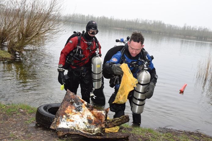 Serge Pellikaan (r) brengt  met een duikmaatje afval uit de Oostplas aan de kant.