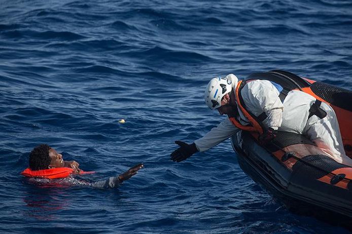 Archiefbeeld van mei. Een reddingswerker helpt een man uit het water nadat een houten boot met meer dan 500 bootvluchtelingen kapseisde nabij Lampedusa, Italië. Meer dan 30 mensen kwamen om.