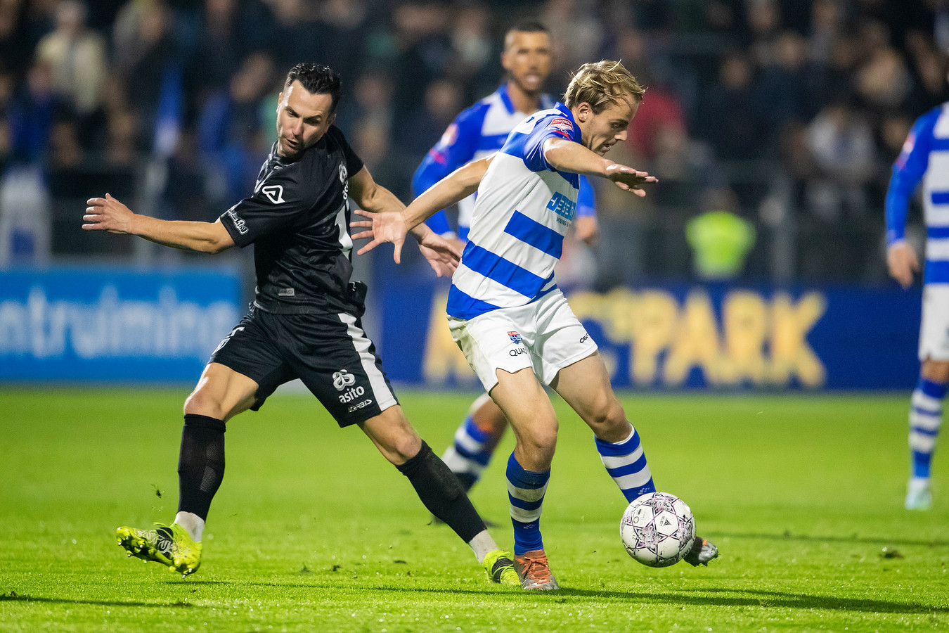 Thomas Bruns in een duel met PEC-speler Thomas van den Belt. De thuisploeg won de ontmoeting met 3-2.