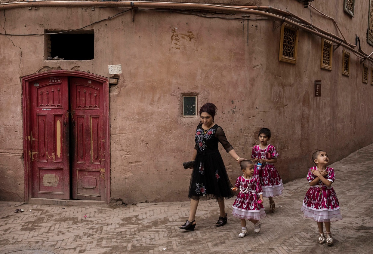 Een vrouw  met haar kinderen in de straten van Kashgar, het culturele hart van de provincie Xinjiang. Beeld Kevin Frayer / Getty Images
