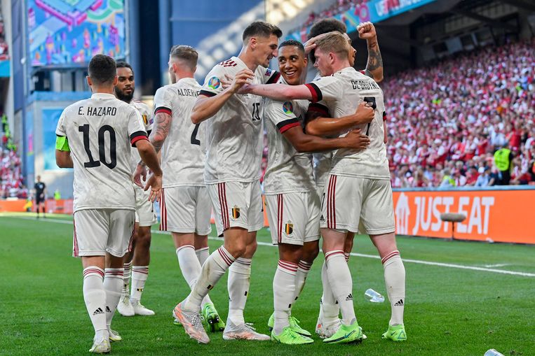 De Rode Duivels omhelzen Kevin De Bruyne na zijn bevrijdende doelpunt tegen Denemarken, donderdag in het Parken-stadion in Kopenhagen. Beeld Photo News