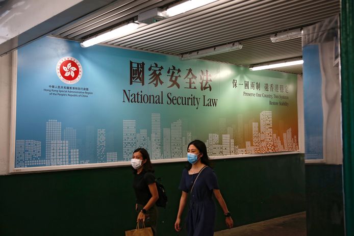 Vrouwen lopen langs een door de regering gesponsorde 'reclame' voor de nieuwe Chinese wet voor nationale veiligheid, die het land ook wil opleggen aan Hongkong.