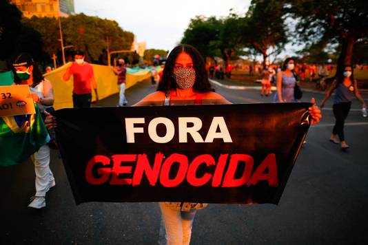 Een demonstrant tijdens de anti-Bolsonarobetoging in de hoofdstad Brasília. ‘Weg met de genocide’, luidt de tekst op het spandoek.