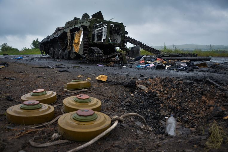 Oekraïense landmijnen bij een vernietigde tank van pro-Russische separatisten in de Donbas, tijdens de strijd in juli 2014. Beeld EPA