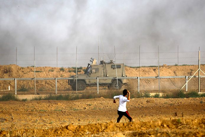 Een Palestijn uit Gaza gooit een steen naar een Israëlisch legervoertuig.