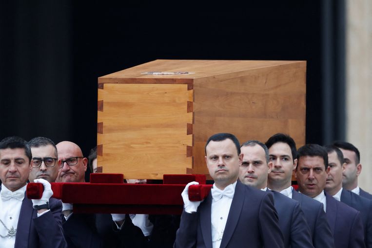 De kist met daarin het lichaam van emeritus paus Benedictus werd vanmorgen vanuit de Sint-Pietersbasiliek naar het gelijknamige plein gedragen. Beeld REUTERS