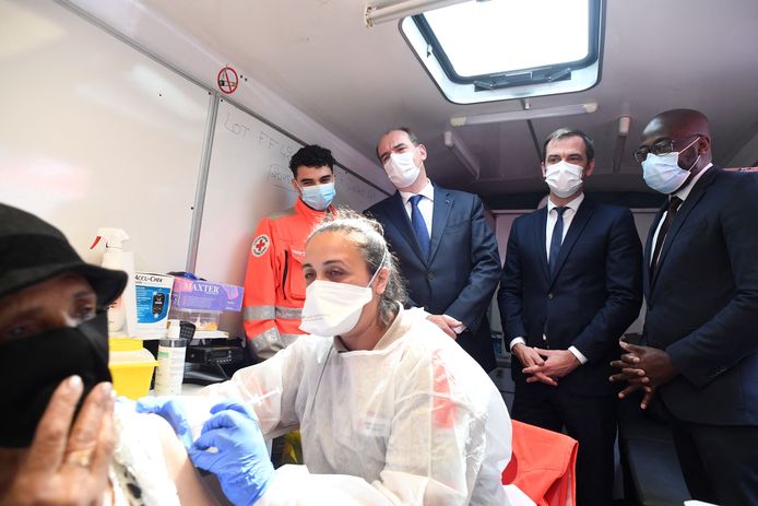 De Franse minister van Volksgezondheid Olivier Veran en premier Jean Castex kijken in Parijs toe hoe een coronavaccin toegediend wordt.