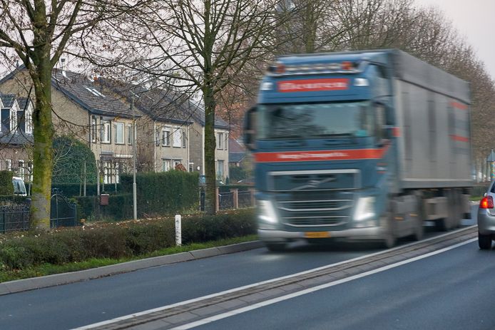Een vrachtwagen passeert Deursen-Dennenburg op de Dorpenweg.