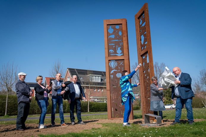 Wethouder Theo Jansen (rechts) onthult samen met Irene Loeff (streepjesshirt) en Mieke Bles (blauw) het kunstwerk Forës op Loovelden.