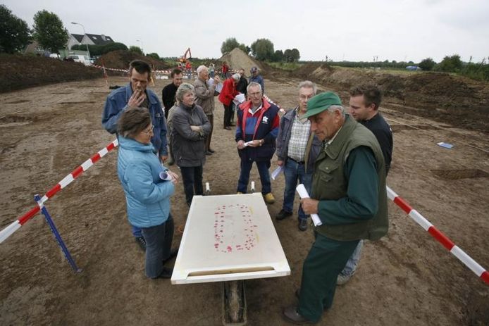 Het voornamelijk uit Kapel-Avezaath afkomstige publiek krijgt uitleg van een archeoloog bij een plattegrond van de oude boerderij. foto Jan Bouwhuis