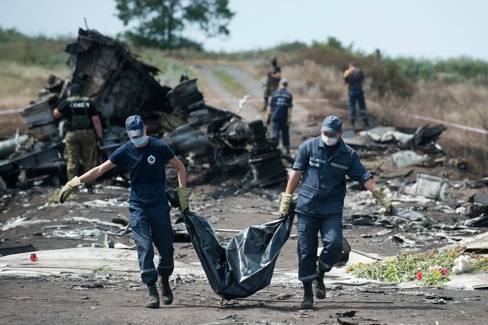 Oekraïense reddingswerkers dragen het lichaam van een MH17-slachtoffer.