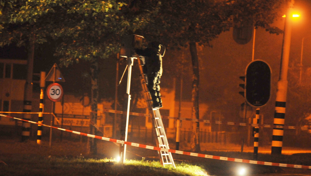 Een medewerker van de EOD onderzoekt een explosief aan een flitspaal, 23 oktober 2011 Beeld ANP