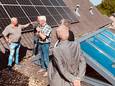Medewerkers van Het Wapen van Reek bekijken samen met wethouder Harold van den Broek de zonnepanelen op het dak.
