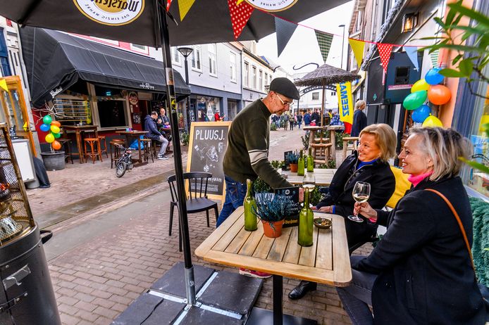 Oud-wethouder Gé Wagemakers serveert een drankje op het terras van zijn borrelcafé aan de Kerkstraat.