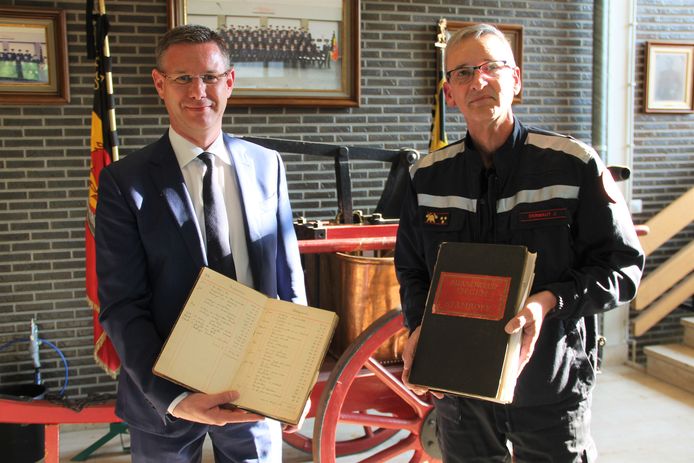 Archiefschepen Kurt Himpe (N-VA) en postoverste Johan Dermaut van de Izegemse brandweer met enkele van de historische documenten die aan het stadsarchief worden geschonken.