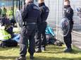 Actievoerders Extinction Rebellion maken zich vast aan een hek.
