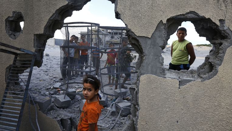 Palestijnse kinderen bij een huis dat getroffen is door een inslag Beeld ap
