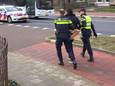 De verdachte wordt met een bewijszak over zijn handen afgevoerd na een zeer ernstige steekpartij aan de Graafseweg in Nijmegen.