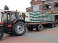 De tractor met volgeladen platte wagen voor de supermarkt in Gramsbergen.