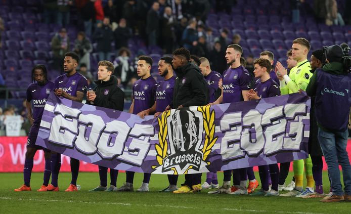 De spelers van Anderlecht met een spandoek voor het twintigjarig bestaan van supportersgroep ‘Mauves Army’.