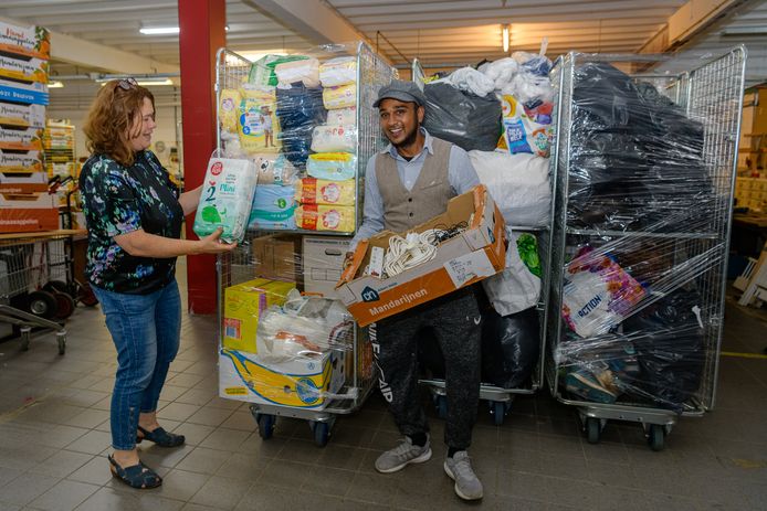 Riet Lenting directeur van de kringloop Zeist heeft weer een aantal karren klaarstaan voor de Afghaanse evacuees. Randez voegt er een doos met laders en verlengsnoeren aan toe, die hij net getest heeft.
