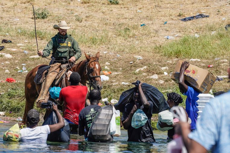 Un agente di frontiera usa le sue redini per fermare gli immigrati haitiani.  Foto AFP