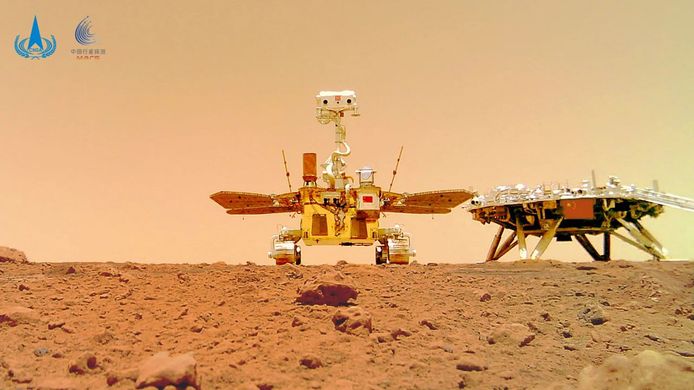 De Chinese marsrover Zhurong naast het landingsplatform met de Chinse vlag op.