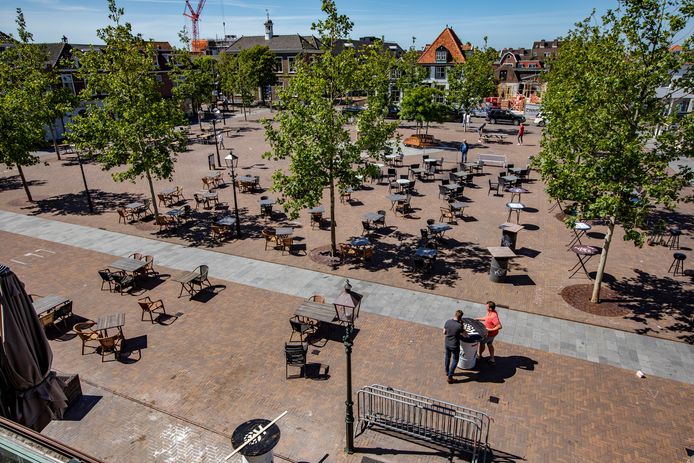 De tafels en stoelen op het Marktplein in ‘s-Gravenzande worden met anderhalve meter afstand neergezet.